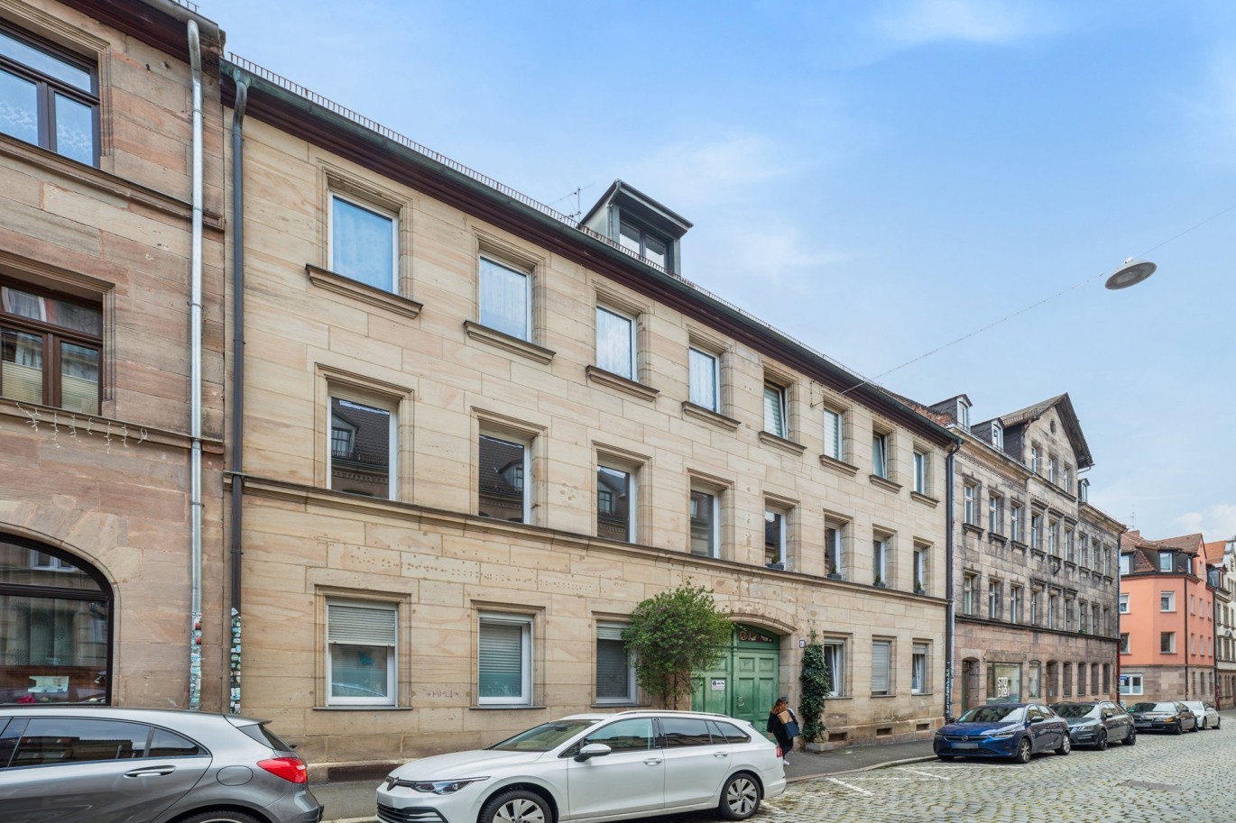 Denkmalgeschütztes Mehrfamilienhaus mit schöner steinerner Fasses und grüner Eingangstür