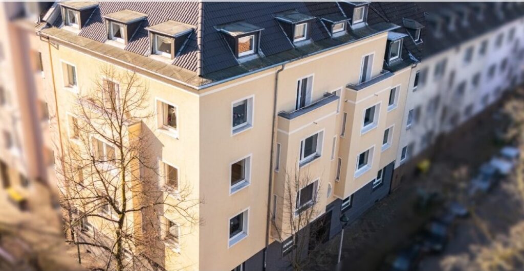 Gelbes mehretagiges Wohngebäude mit modernisierter Fassade