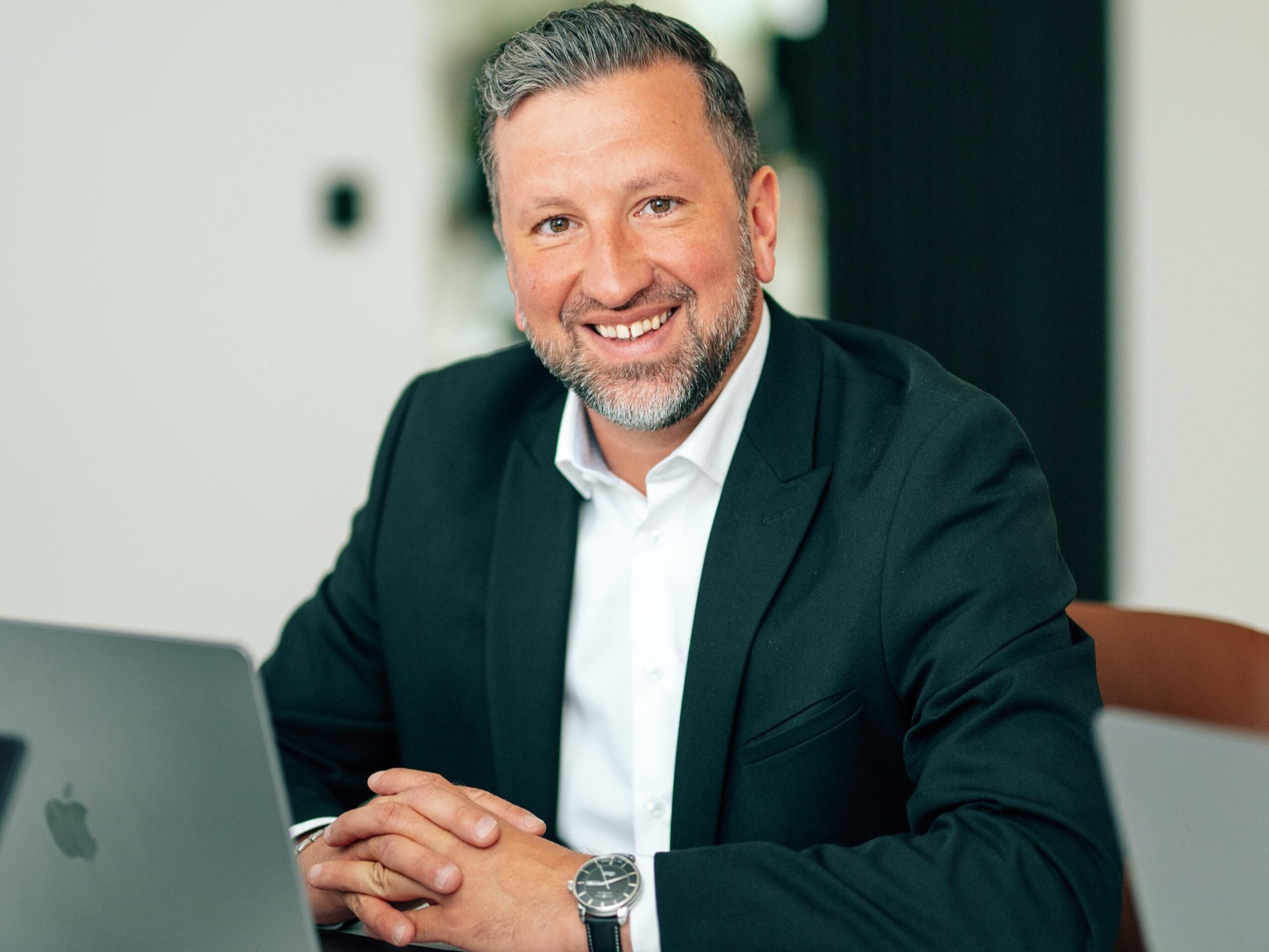 Christopher Lemm sitzend im Portrait mit MacBook