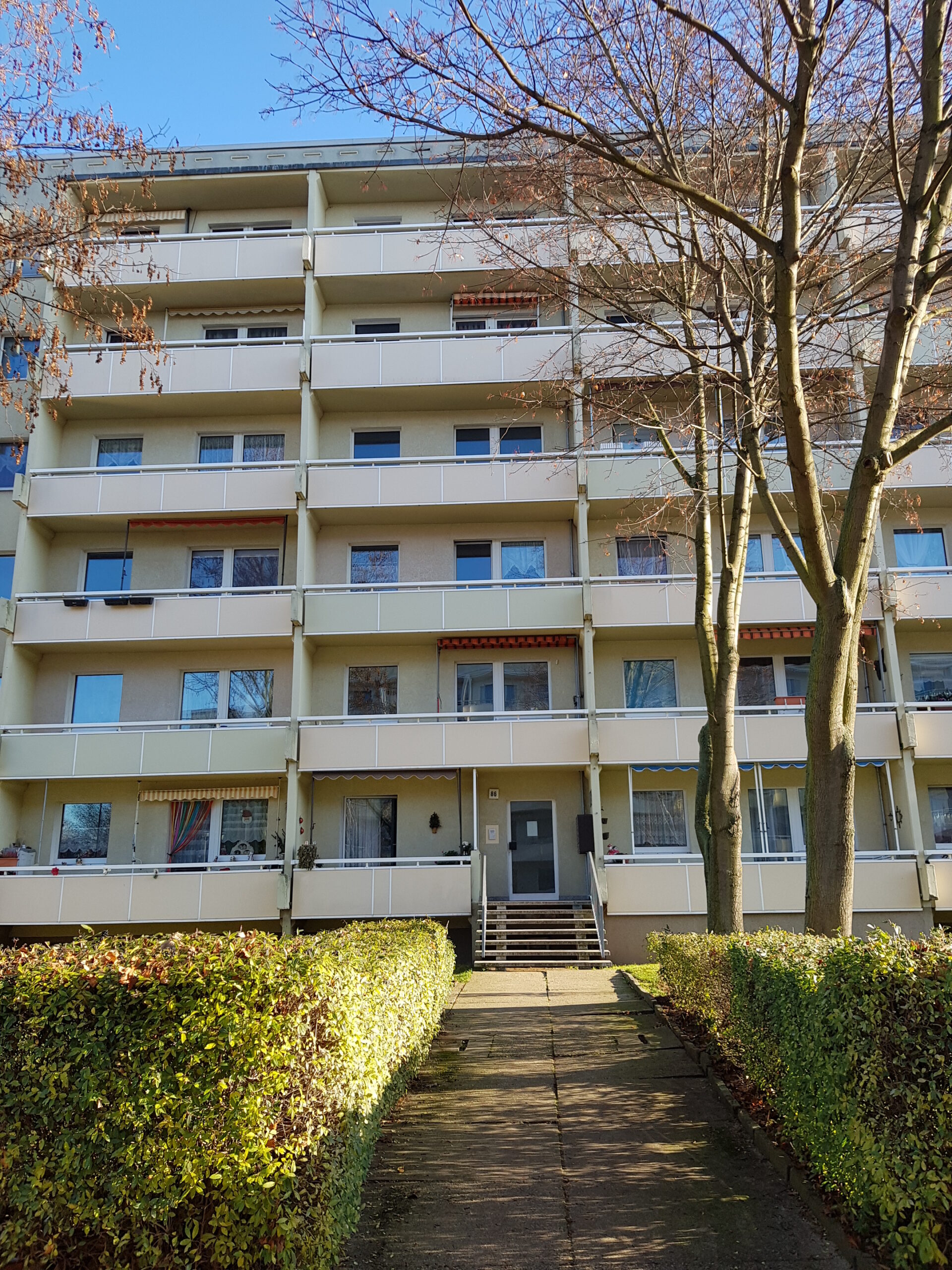 Hellgelbes Mehrfamilienhaus mit Balkonen